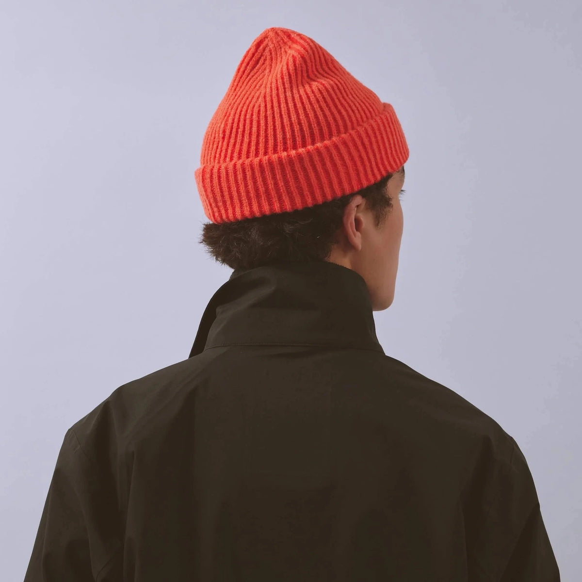 Våga Midweight Beanie in orange-red – worn, angled back view