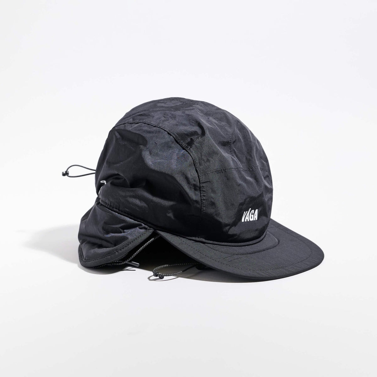 Vaga Padded Hiker Cap in Schwarz – schräge Vorderansicht mit heruntergeklappten Ohrenklappen