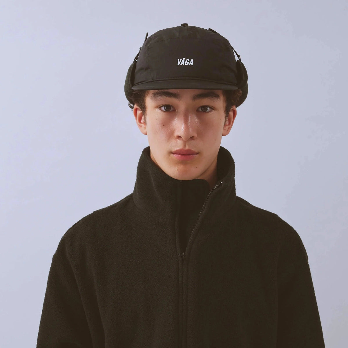 Vaga Padded Hiker Cap in Schwarz – getragen, Vorderansicht mit hochgeklappten Ohrenklappen