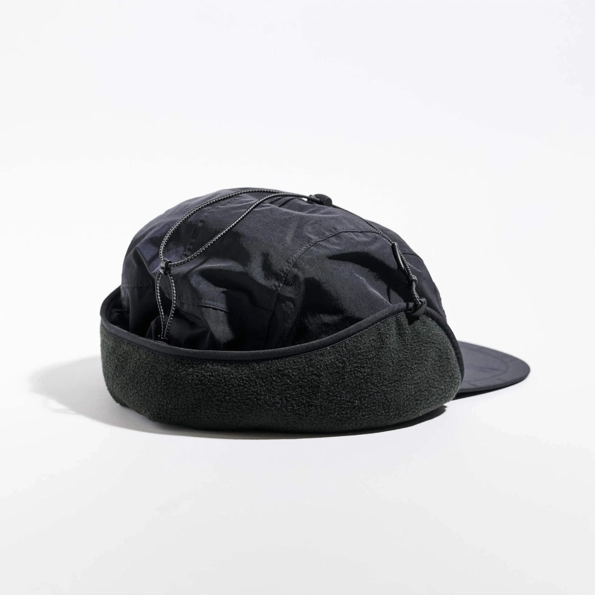 Vaga Padded Hiker Cap in Schwarz – schräge Rückansicht mit Fleecerand und hochgeklappten Ohrenklappen