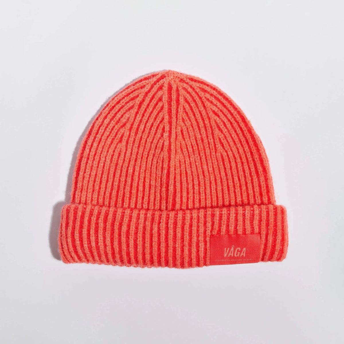 Våga Midweight Beanie in Orangerot – flach liegend, Vorderseite mit Label